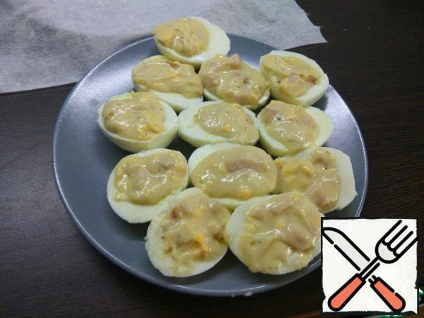 Prepare the filling: chop boiled egg yolks, mix with the sauce. To fill half of egg whites stuffed and put into the refrigerator for 15-20 minutes to make the sauce a little bit stuck. So eggs will be easier to roll in breadcrumbs.