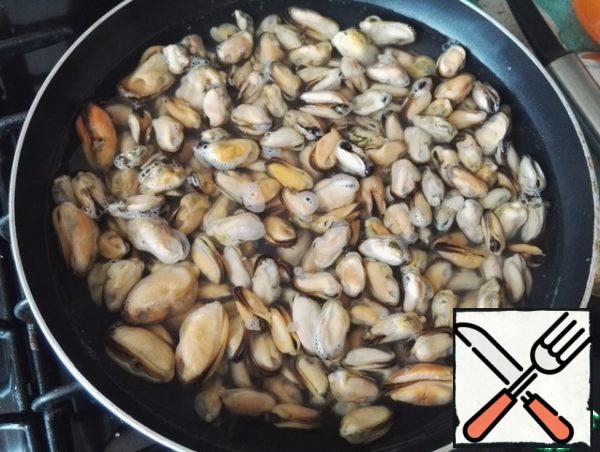 First, prepare the mussels. I use boiled frozen. To do this, put the frozen mussels in boiling water and wait for the first signs of re-boiling. Once boiled, drain, set aside.
