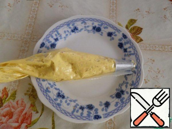 Prepared yolk-sour cream mass spread in a pastry bag.