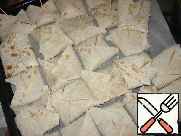 Fold the envelope, fastened with a toothpick, (thought to bake in the oven), then when everyone was ready, toothpicks pulled and fried in a frying pan, add a little vegetable oil, fry for a minute on each side, first put the seams down. Instead of lavash, you can use pancakes.