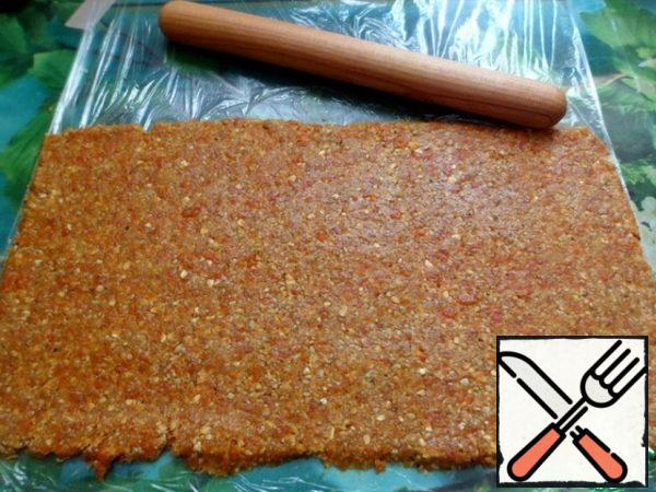 Spread the mass with your hands on the food film and roll it out with a rolling pin. The mass does not stick at all and rolls out well. If it suddenly sticks, add more ground oat flakes or roll out between two layers of film. Trim the edges, they are easily cut off with a silicone spatula.
