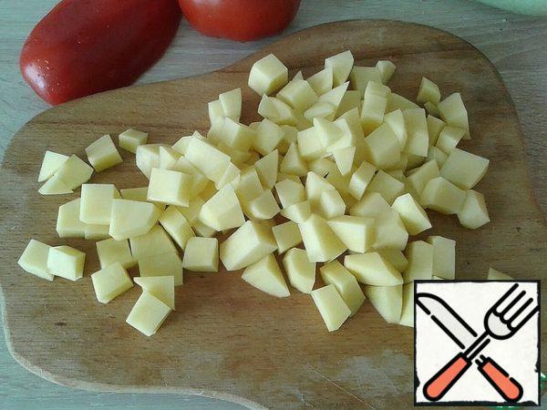 Cut the potatoes into cubes. As soon as the broth boiled, potatoes are sent to cook it.