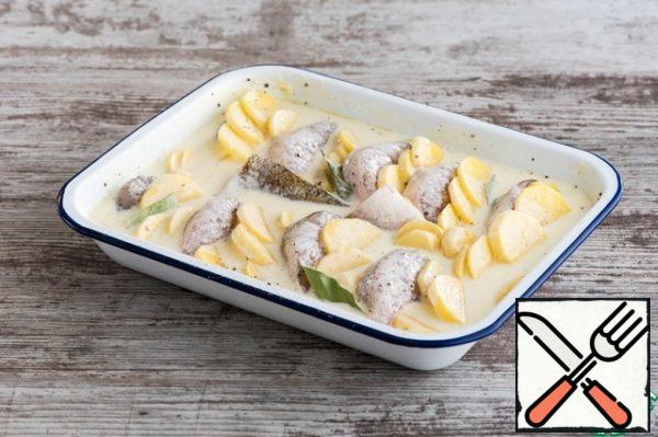 Heat the milk in a ladle almost to a boil, remove from heat, cut into pieces and melt the butter in hot milk, mix. Cool slightly and mix with sour cream. Pour the sour cream mixture over the fish and potatoes and cover the mold with a lid or foil.
