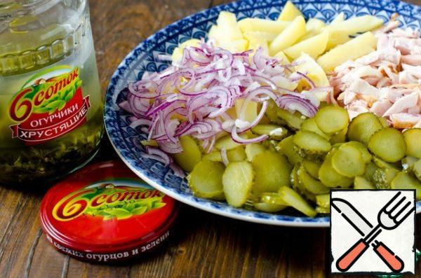 Boiled potatoes cut into small slices, cucumbers - thin slices, and red onion - half rings.
