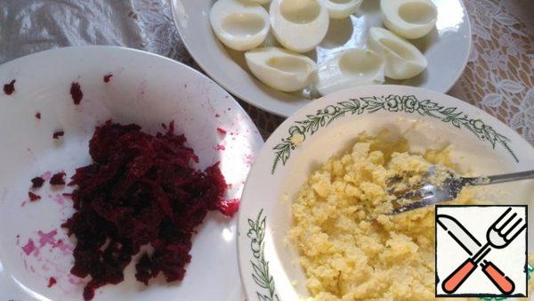 Put the beets to cook for 40-60 minutes, until soft.
Put the eggs in cold water, pour 1 teaspoon of salt, put on medium heat and wait for 15 minutes, then drain the hot water, fill with cold water and allow to cool for 15 minutes.
Eggs are cleaned from the shell, cut in half, remove the yolks in a separate bowl. The yolks, mash well with a fork, add the herring caviar and 1-2 tbsp of mayonnaise, mix well.
The finished beetroot peel and grate, give  it to cool a bit. 