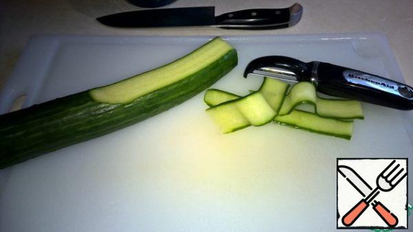 Cut the cucumber into thin strips with the help of a housekeeper (vegetable peeler). The first strip, which is almost exclusively from the peel, is thrown away.
When we get to the core with the seeds, we can start from the opposite side.
