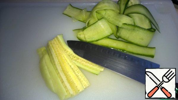 The core with seeds cut into thin plates with a knife. When finished, put the strips of cucumber in a bowl.