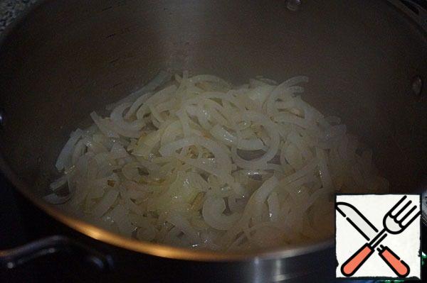 In a saucepan with a thick bottom, heat the butter and vegetable oil, put the onion, fry until lightly changing the color.