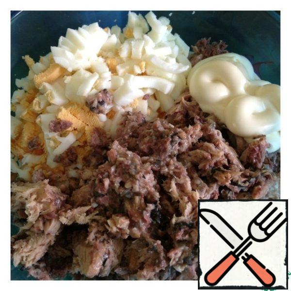 Cut the egg into cubes and season with mayonnaise. Drain the excess liquid from the canned fish (I have mackerel), mash the fish with a fork.
