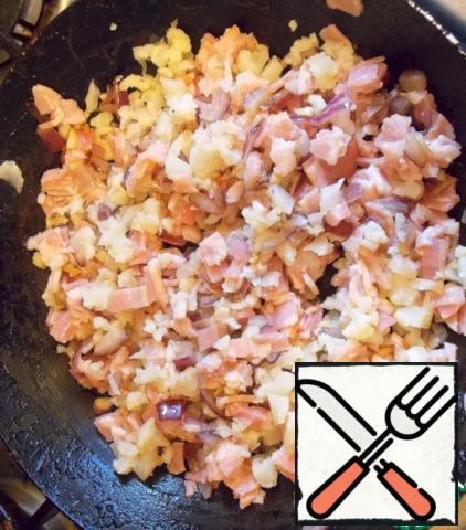 Onions and garlic finely cut and fry in the same pan for 3 minutes. Cut bacon and cauliflower. Add to the fried onions and fry for another 3-4 minutes. Let cool slightly.