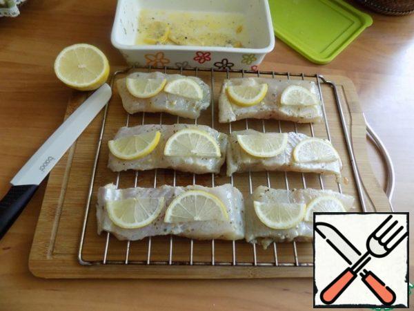 Turned on the oven grill. Posted pieces of walleye on the grill from the oven. On each piece put 2 half-slices of lemon. In the preheated oven to t-200 C put a grill with fish under the grill for 15 minutes. Framed down the pan that there was dripping with oil and juice with walleye.