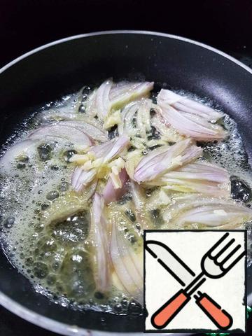 Onions cut into feathers, finely chop garlic.
In a frying pan, melt the oil, fry the onion and garlic for a few seconds.