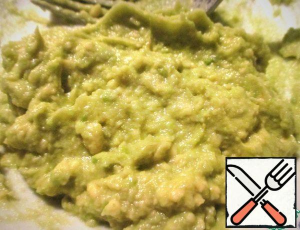 Choose a ripe avocado.
Cut the avocado in half, remove the stone. Take out the pulp with a teaspoon and put it in a bowl.
Pour lemon juice and mash with a fork.