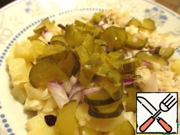 Cut the pickled cucumber in half lengthwise and thinly slice these halves.
