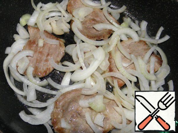 Then clean the onion, cut into half rings and add to the pan to the meat.