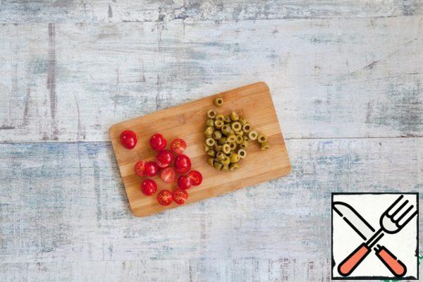 Cut the olives and cherry tomatoes in half.
