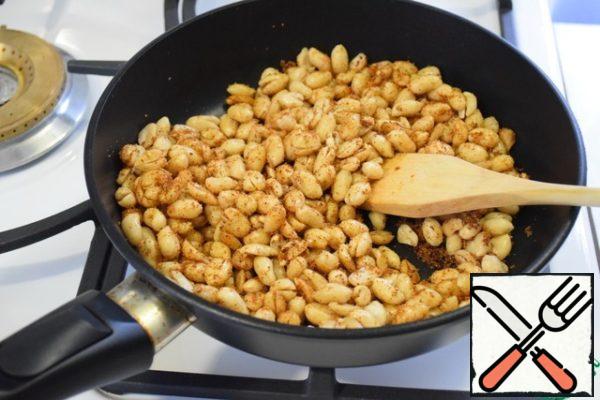 In a frying pan, heat vegetable oil, add sugar, curry, garlic powder, black pepper and burning red. Stir and hold for a couple of minutes (you will hear the intoxicating aroma of spices), add the peanuts and stirring occasionally, hold on fire for about 3-4 minutes.