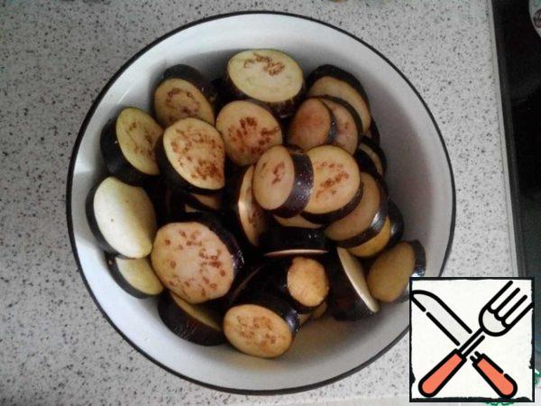 Cut the eggplants into slices, sprinkle them with salt and leave for an hour.
