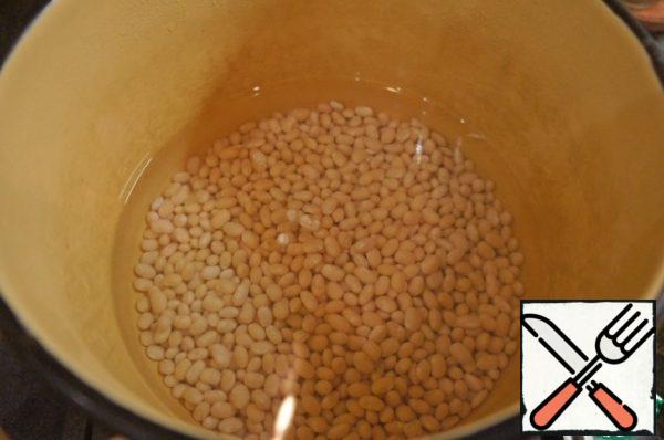 Soak the beans overnight (you can take a jar of canned white beans (400 g), draining the liquid and rinsing with cold water).