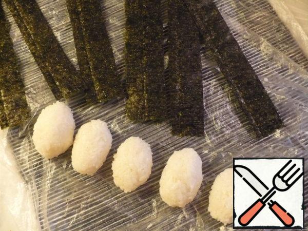 I cook rice no more than 10 minutes. Try to sustain time intervals because correctly cooked rice is 99% that rolls at you will turn out.  So, rice with wet hands, shape the cutlets, sheet nori, cut with scissors into strips of about 3 cm at 6 pieces.