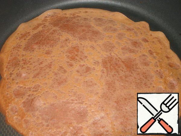 From the dough in a well heated pan to fry thin pancakes. Each pancake fry on both sides and grease with butter.