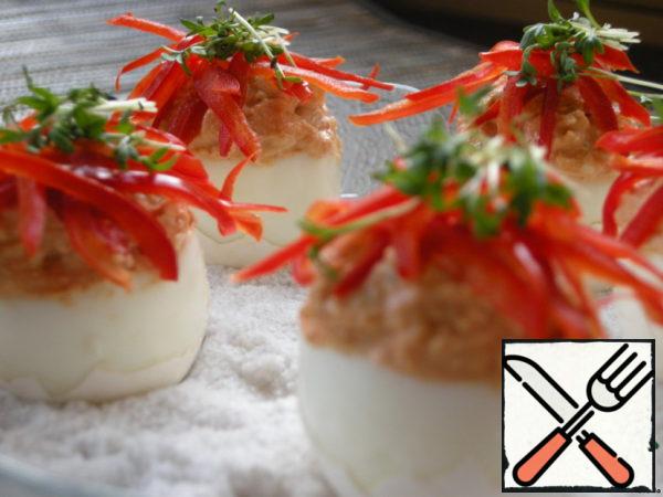 Stuff the eggs, fix them vertically with coarse salt in a plate, sprinkle pepper on top, lay out the salad.