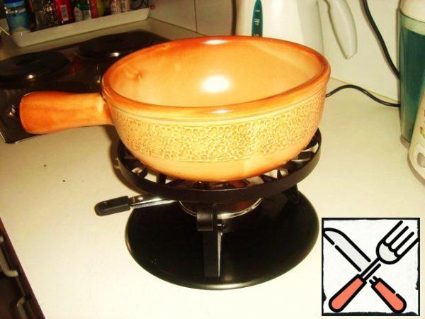 To make fondue, you must have a ceramic or cast-iron fondue mold complete with a metal stand and a burner at the bottom.
Before proceeding with everything described below, turn on the oven at 200 degrees. During the first few steps, it should warm up.
So, go ahead!
