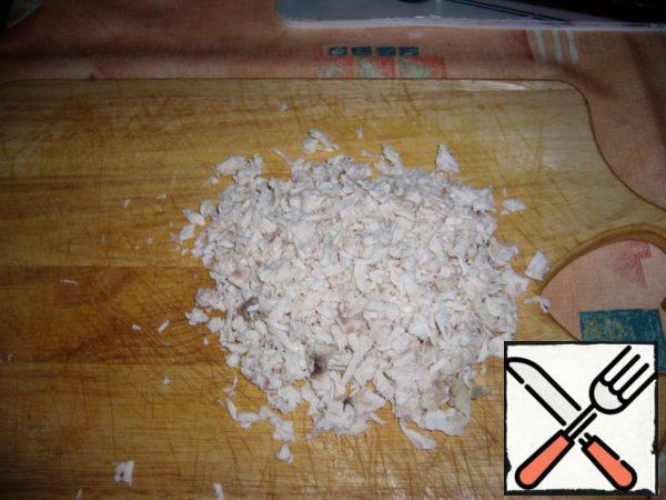 While the honey agarics mushrooms are cooling, cut the boiled chicken breast small pieces.