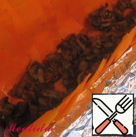In a long rectangular shape for bread spread the foil, so that there are long hanging edges, lubricate well with oil.
Cover the bottom and sides of the form with strips of pumpkin, salt and pepper,
spread on the bottom layer of mushrooms.