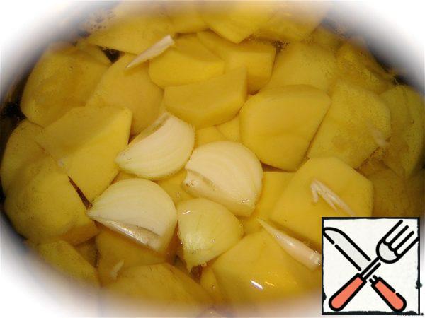 To begin, clean the potatoes, cut it into several parts and put to cook. In a pot of potatoes immediately throw cleaned and cut into 4 parts onion. After 20 minutes, add salt and Bay leaf. Cook for another 3-5 minutes.