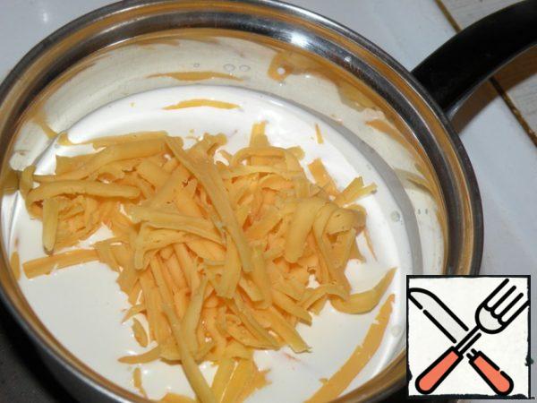 Heat the cream, but do not boil, dissolve the cheese in them (grate on a coarse grater).