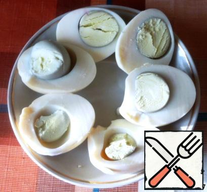 Boiled eggs cut in half and remove the yolks. Clean the shrimp. Part of the shrimp is left to decorate the finished dish.