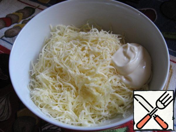 Cheese grate on a fine grater, add the grated garlic and mayonnaise mix thoroughly.