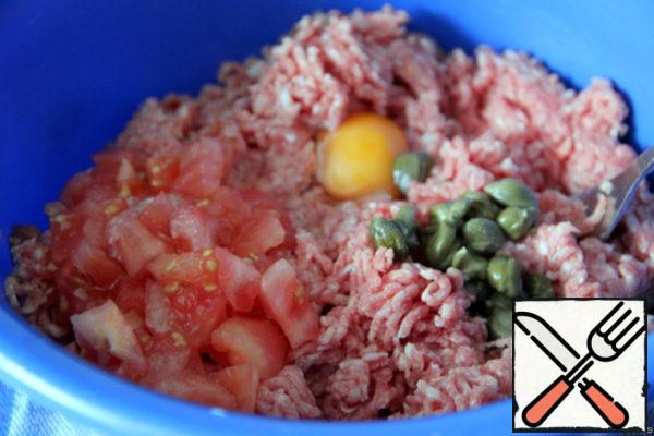 Add egg, capers (or pickled cucumber, cut into cubes), cubes of canned (fresh) tomato without skin to minced meat.