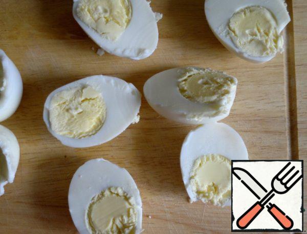 Boil eggs, cool, peel, cut into halves.