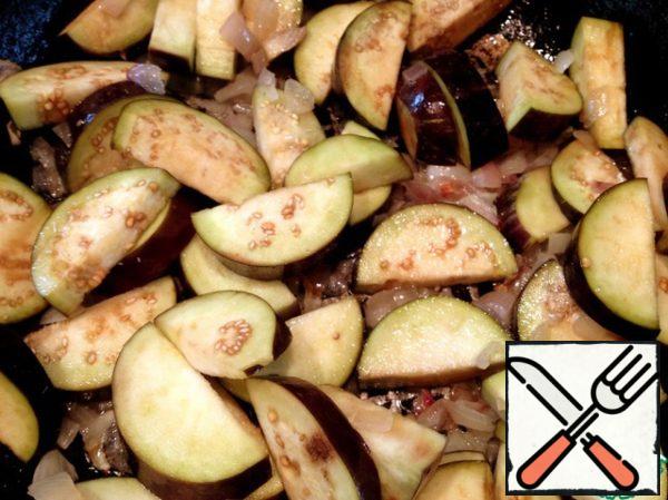 At this time, heat the oil in a frying pan, cut the onion and fry it until Golden brown, wash the eggplant and add to the onion. I do not add more oil so it's not too bold, if completely dry pan add a little water and on medium heat bring the eggplants until tender.