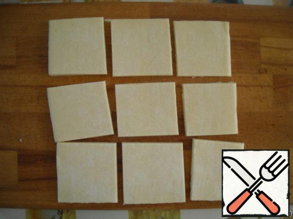 The dough is not much defrost, cut it into squares.