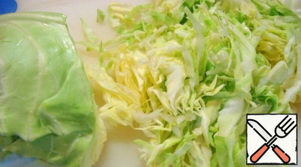 To chop the cabbage. Season with salt, add the sugar and gently mash it.