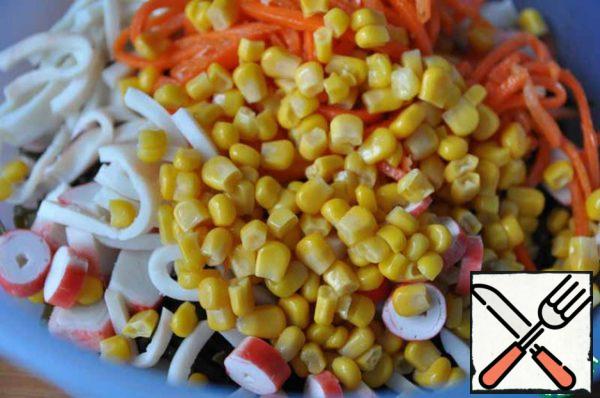 Add canned corn, it is also traditionally combined with crab sticks.
Mix the salad.