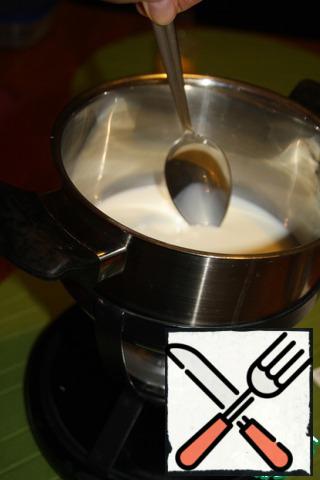 Pour milk into the fondue form, turn on the burner and bring the milk to a boil, stirring constantly, so that no foam is formed. 
