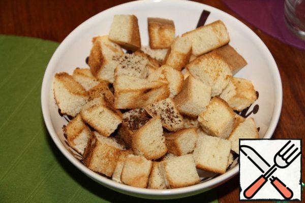 Prepare the croutons: cut the bread into large cubes (about 2 cm by 2 cm), fry in a dry frying pan.
