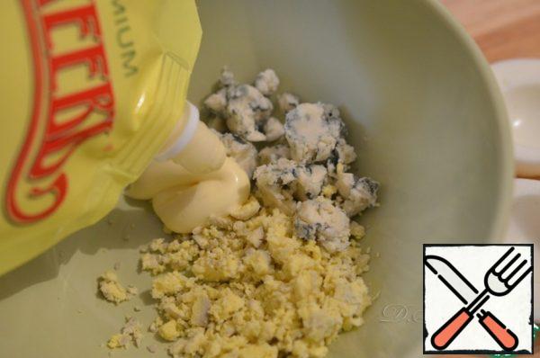 Well, the snack itself is prepared, in general, very simply. Cut the boiled eggs and carefully remove the yolks. Mix the yolks, blue cheese and a little mayonnaise to make a homogeneous mass.
