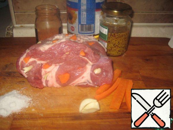 In the meat with a knife to make holes. In them lay pieces of carrot and garlic. If the piece is flat, roll it up and tie it with twine.