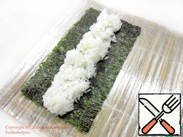 Distribute the rice in the center of the nori leaf along its entire length. Not be pressed on it. It should look like the photo.