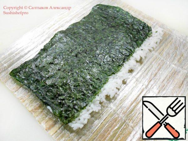 Flip the "nori" with rice so that the side where there is no rice for algae is closer to you. Look at the photo.
