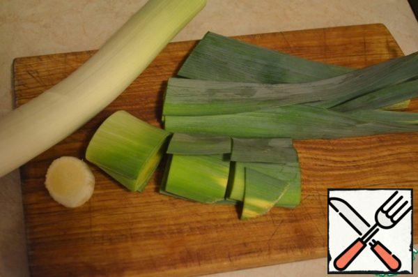 For decorating we need green jelly. We'll make it out of leek. To do this, cut the onion into large pieces (together with the white part).