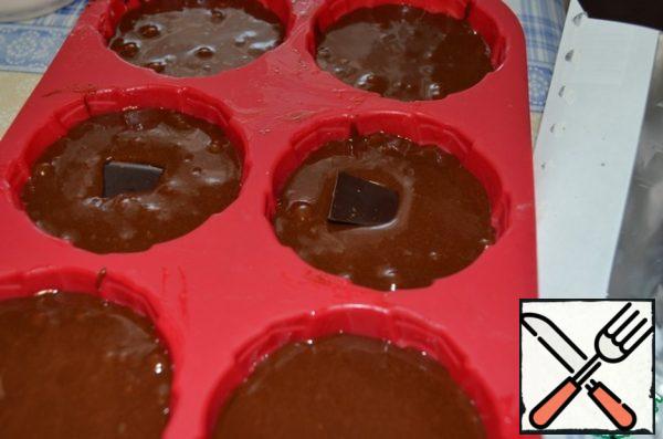 Put 2-3 slices of chocolate in each mold, slightly down. Put in a preheated 200 degree oven for 7-8 minutes. It's time for the chocolate to stay liquid inside.