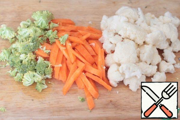 Broccoli and cauliflower disassembled into inflorescences, carrots shred into thin strips.