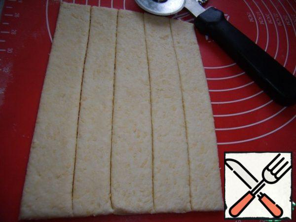 Roll out the cooled dough into a layer about 5 mm thick and cut into narrow strips 2 cm wide and about 15 cm long.
