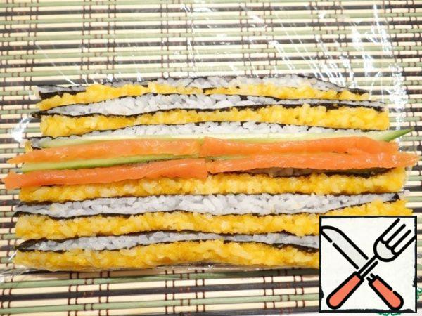Place thin strips of cucumber and salmon on top.
